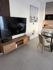 a living room with a large television and a table at Slatine Residence apartament No2 in Slatine