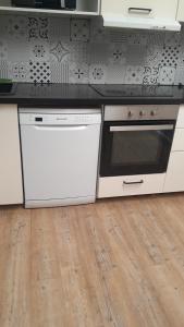 a kitchen with white appliances and a wooden floor at Maison Conviviale amiens in Amiens