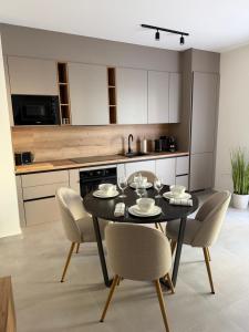 a kitchen with a black table and chairs in a room at Slatine Residence apartament No2 in Slatine