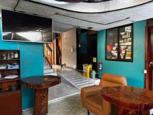 a living room with two tables and a tv at Transilvania in Baños