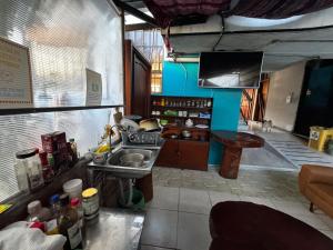 a kitchen with a sink and a tv in a room at Transilvania in Baños