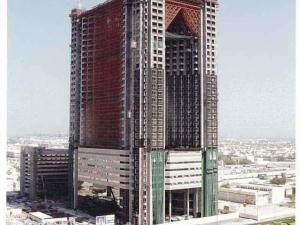 two tall buildings are under construction in a city at Fairmont Dubai in Dubai