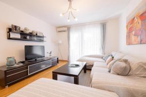 a living room with two couches and a flat screen tv at Sea & Sky Retreat in Makarska