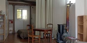 a room with a table and chairs and a bedroom at Studio privé - maison de village in Valensole