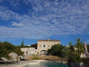 a villa with a swimming pool and a building at Les Dolines in Balazuc