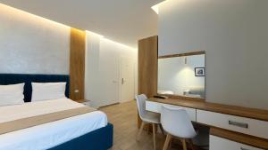 a hotel room with a bed and a desk with chairs at HotelApart - DelMar in Durrës