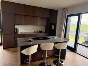 a kitchen with a island with two bar stools at ScenicOceanview 4Free parking space 18 mins Downtown in Álftanes