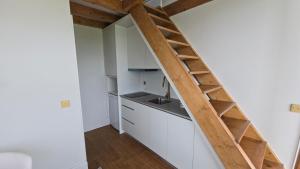 a kitchen with white cabinets and a wooden ladder at Caza de Cima de Villa in Penafiel