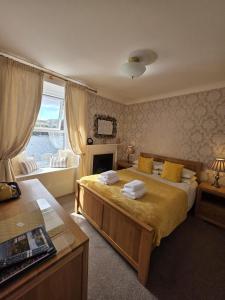 a bedroom with a bed and a fireplace and a window at Mishnish Hotel in Tobermory