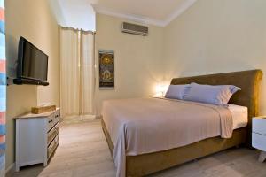 a bedroom with a bed and a flat screen tv at Sunset Villa in Jimbaran +127 photos