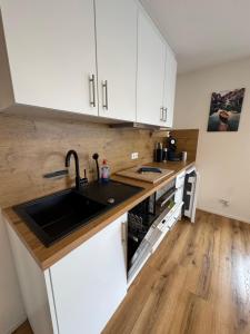 a kitchen with white cabinets and a sink at Spatzennest am Bodensee in Bermatingen