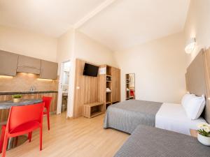 a hotel room with two beds and a kitchen at Hotel Residence Vallecorsa in Vada