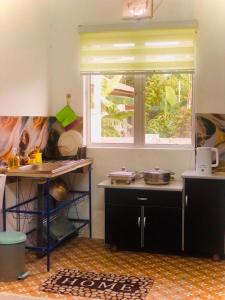 a kitchen with a window and a table with pans at Rumah Teduh Desa in Kuala Rompin