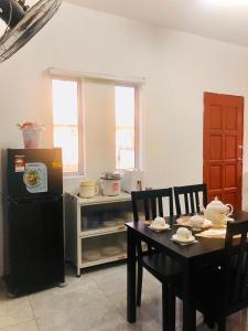 a kitchen with a table and a refrigerator and a table and chairs at Rumah Teduh Desa in Kuala Rompin +18 photos