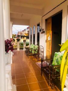 a porch with benches on a house at Rumah Teduh Desa in Kuala Rompin