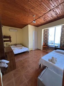 a room with two beds and a large window at Bach-Ana in Ureki