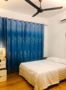 a bedroom with a bed and a blue curtain at Rumah Teduh Desa in Kuala Rompin
