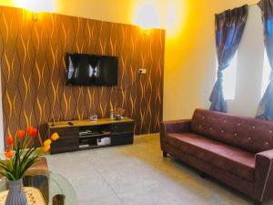 a living room with a couch and a tv at Rumah Teduh Desa in Kuala Rompin