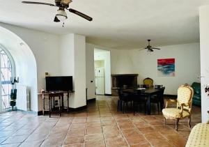 a living room with a table and chairs and a ceiling fan at View Ischia & Procida -Villa Lamberti Casa Panorama in Monte di Procida