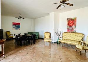 a dining room with chairs and a table and a ceiling fan at View Ischia & Procida -Villa Lamberti Casa Panorama in Monte di Procida