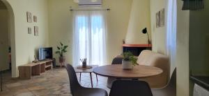 a living room with a table and chairs and a television at Ze Di Ma House in Kythira