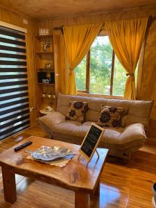 a living room with a couch and a coffee table at Cabaña Payer in Villarrica
