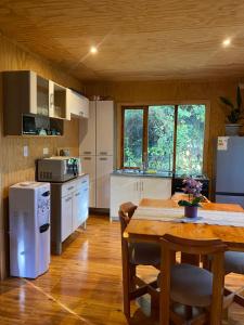a kitchen with a wooden table and a dining room at Cabaña Payer in Villarrica