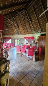 a dining room with pink chairs and a table at Afrika Lodge in Kempton Park