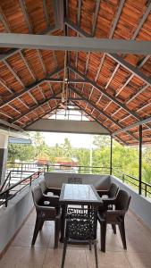 a patio with a table and chairs on a balcony at Lakeside Meadows- Diamond Homestay in Kollam