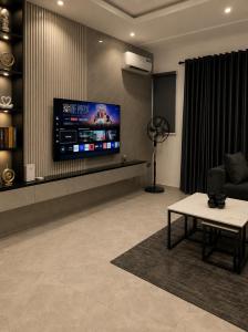a living room with a tv and a couch and a table at Ileero Homes The Beachfront in Lekki