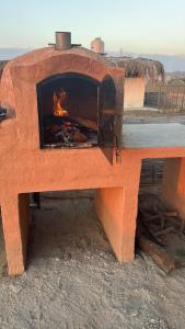a brick oven with a fire inside of it at Casa Vichayito - Los Órganos in Los Órganos