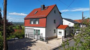 a white house with an orange roof at Ferienhaus Weitblick in Dresden