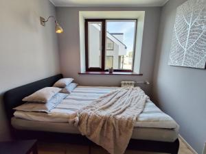 a bed in a room with a window at Turu 6, Quiet Central Apartment in Haapsalu