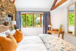 a bedroom with a bed and a stone wall at The Wagon in Michaelstow