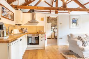 a kitchen with white cabinets and a living room at The Wagon in Michaelstow