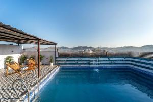a swimming pool with a bench and a water fountain at Mangal Residency in Bedla