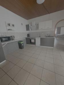 a large kitchen with white cabinets and a tile floor at Apartment Wesel in Wesel
