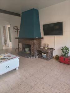 a living room with a brick fireplace with a flat screen tv at Eco- Refugio Centenario in Sagunto