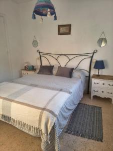 a bedroom with a large bed and a table with a lamp at Eco- Refugio Centenario in Sagunto +26 photos