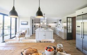 a kitchen with white cabinets and a table with food at Hilltop in Woodbridge