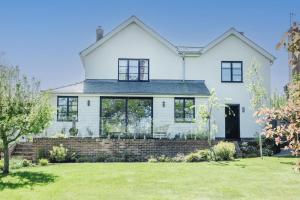 a white house with black windows and a yard at Hilltop in Woodbridge