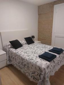 a bedroom with a bed with black pillows on it at Casa MENDEZ - ALLARIZ in Ourense