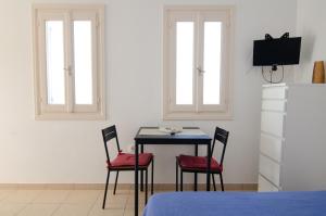 a dining room with a table and two windows at Mylopota Studio I in Mylopotas