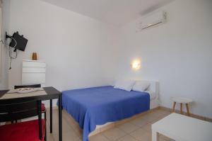a bedroom with a bed and a table and a desk at Mylopota Studio I in Mylopotas