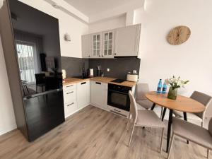 a kitchen with a table and a dining room at Apartament 15 in Lębork