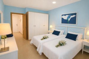 a bedroom with two beds with flowers on them at GOLDEN BEACH MOGAN in Puerto de Mogán