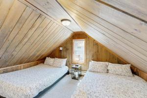 two beds in a room with wooden walls at Jay Peak Getaway on Trout River in Montgomery +68 photos