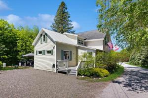 a white house with a porch and a driveway at Jay Peak Getaway on Trout River in Montgomery