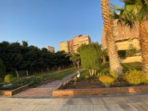 a park with palm trees and buildings in the background at Nile residence in Al Kawāmil Qiblī