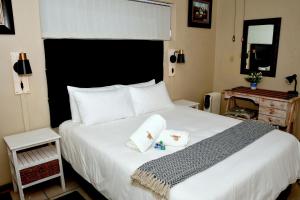 a bedroom with a large white bed with two pillows at Calamari Self Catering in De Kelders +112 photos